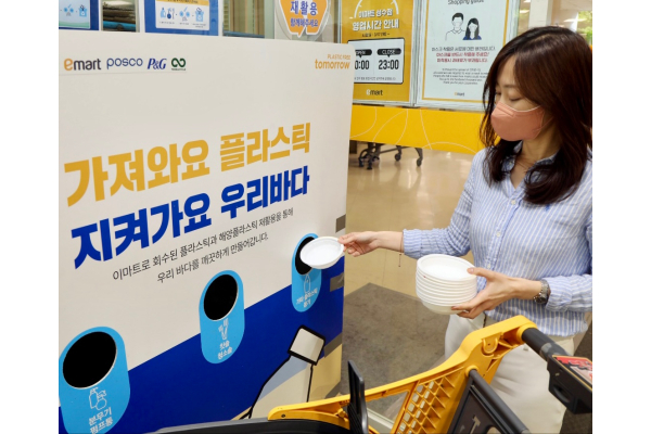 소비자가 이마트 성수점에 설치된 플라스틱 회수함에 햇반 용기를 투입하고 있다