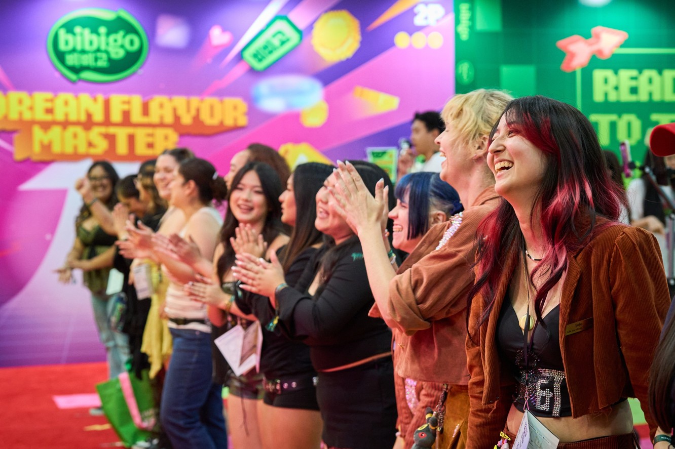 'KCON LA 2026'에 마련된 비비고 부스에서 관람객들이 즐거워하며 모션 챌린지에 참여하고 있다